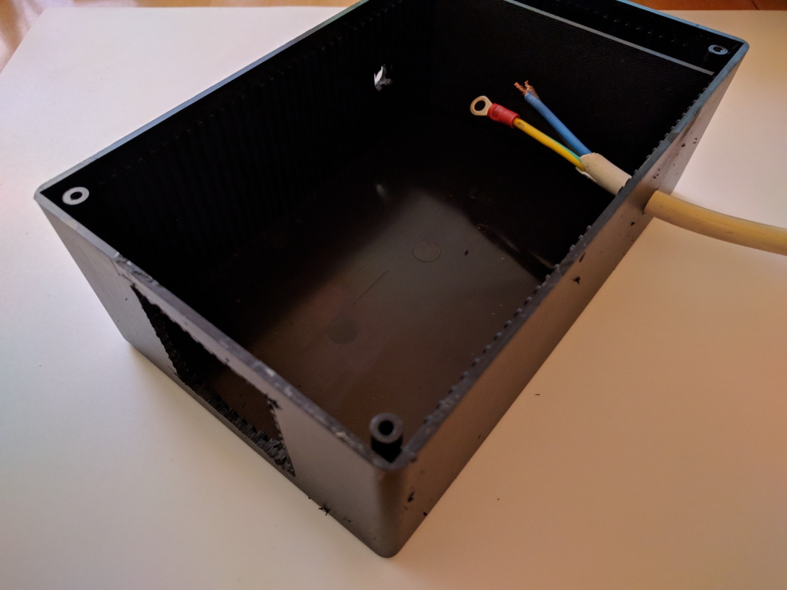 Durchbrüche und Bohrungen in Kunststoffbox angebracht - die eine Hälfte des Kabels in der Kunststoffbox zu sehen mit Steckverbinder